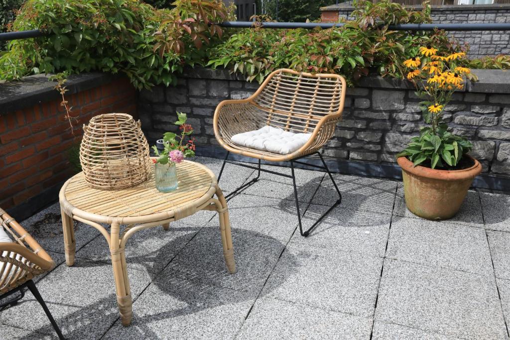 a patio with two chairs and a table and a chair at B&B De Zwanebloem in Amsterdam