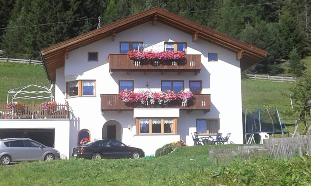 a white house with two balconies with flowers on it at Apart Ramona in Serfaus