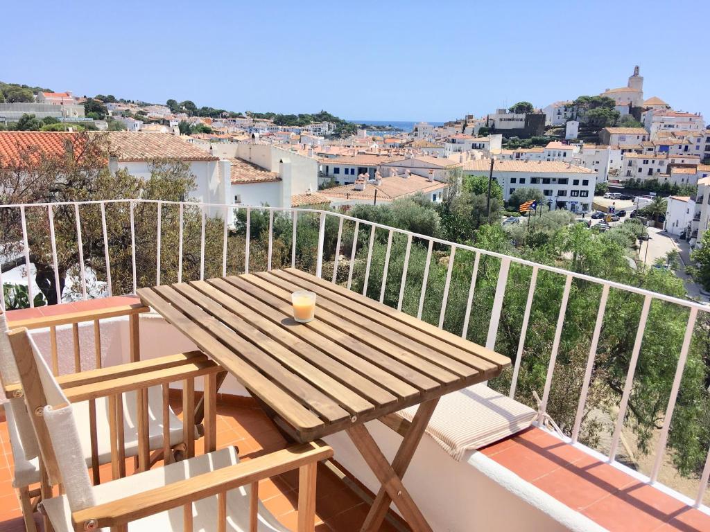 a wooden table on a balcony with a view of a city at Ses Terrasses in Cadaqués