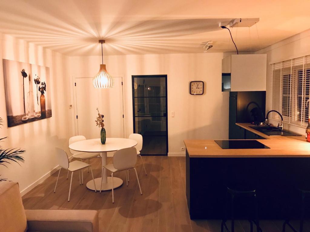 a kitchen with a table and a white table and chairs at Residentie Lenthe in De Haan