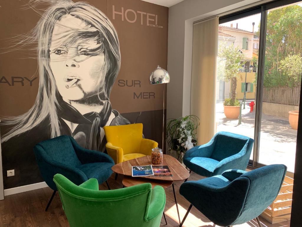 a room with chairs and a large painting of a woman at Holidays & Work HOTEL in Sanary-sur-Mer