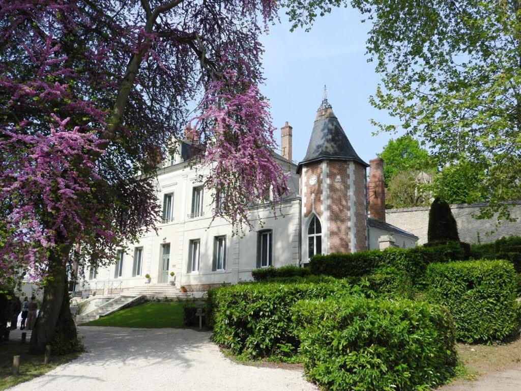 uma grande casa branca com uma torre e árvores em Château des Basses Roches em La Chaussée-Saint-Victor