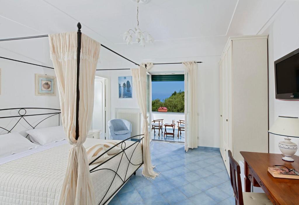 a bedroom with a bed and a table and chairs at Parco Vittoria Holidays House in Anacapri