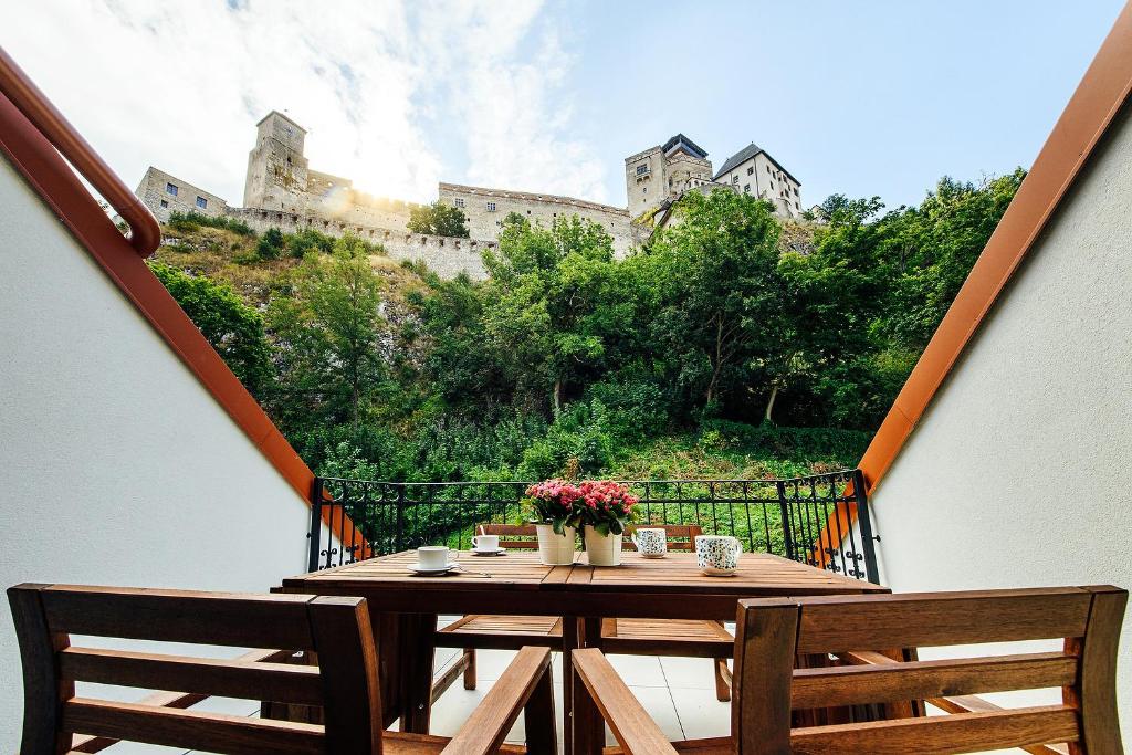 una mesa y 2 sillas en un balcón con un edificio en Loft v historickom centre, en Trenčín