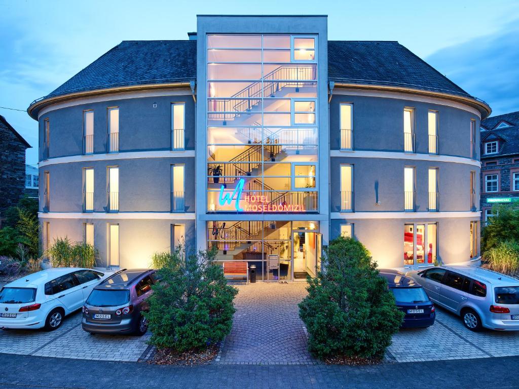 ein großes Gebäude mit davor geparkt in der Unterkunft Hotel Moseldomizil in Mülheim an der Mosel