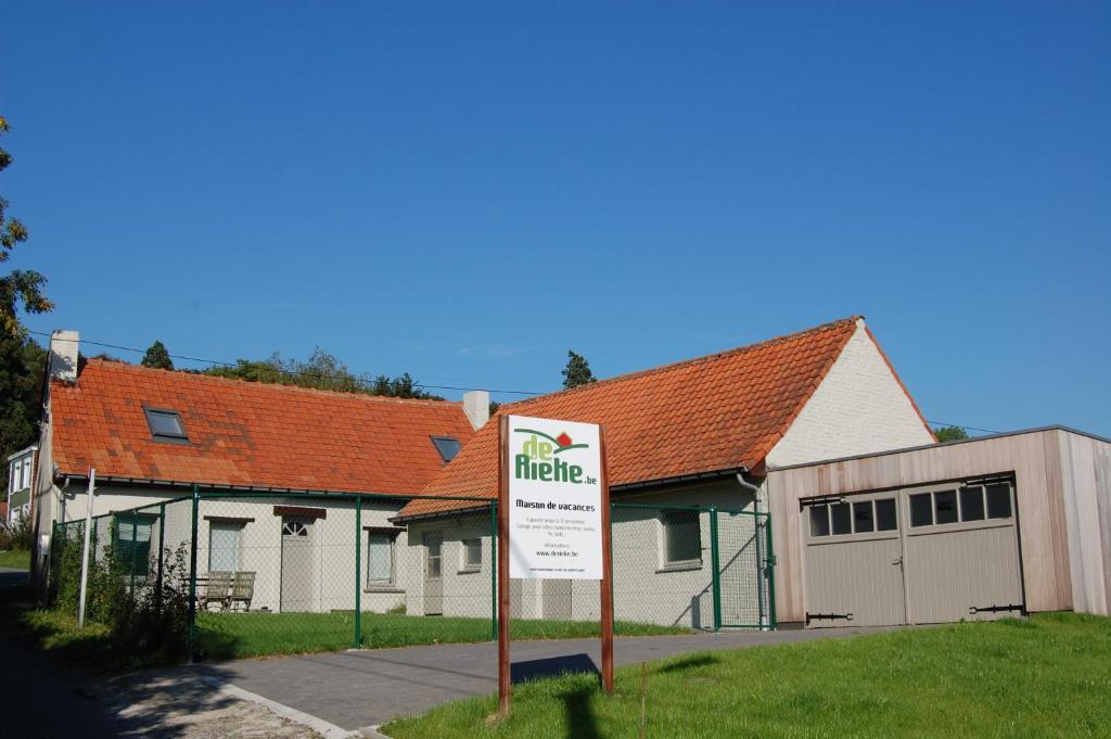 une maison avec un panneau devant elle dans l'établissement De Rieke, à Ronse