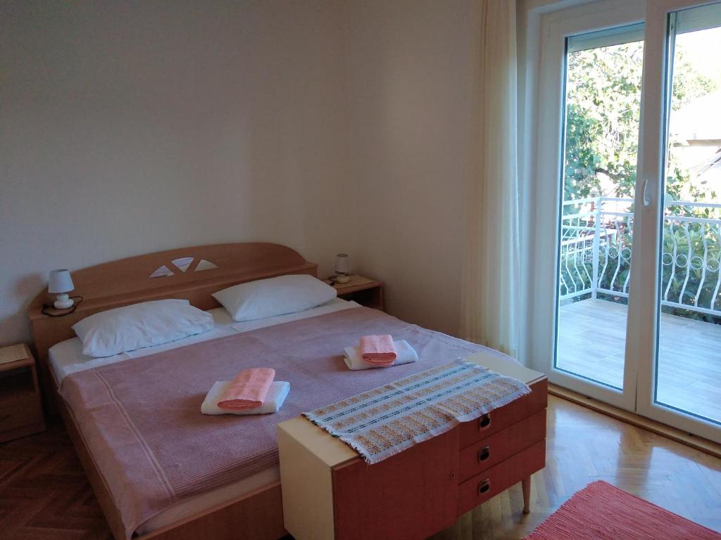 a bedroom with a bed and a large window at Soba Željka in Bribir