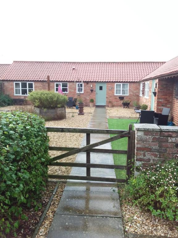 una valla de madera frente a una casa en Swallow cottage en Louth