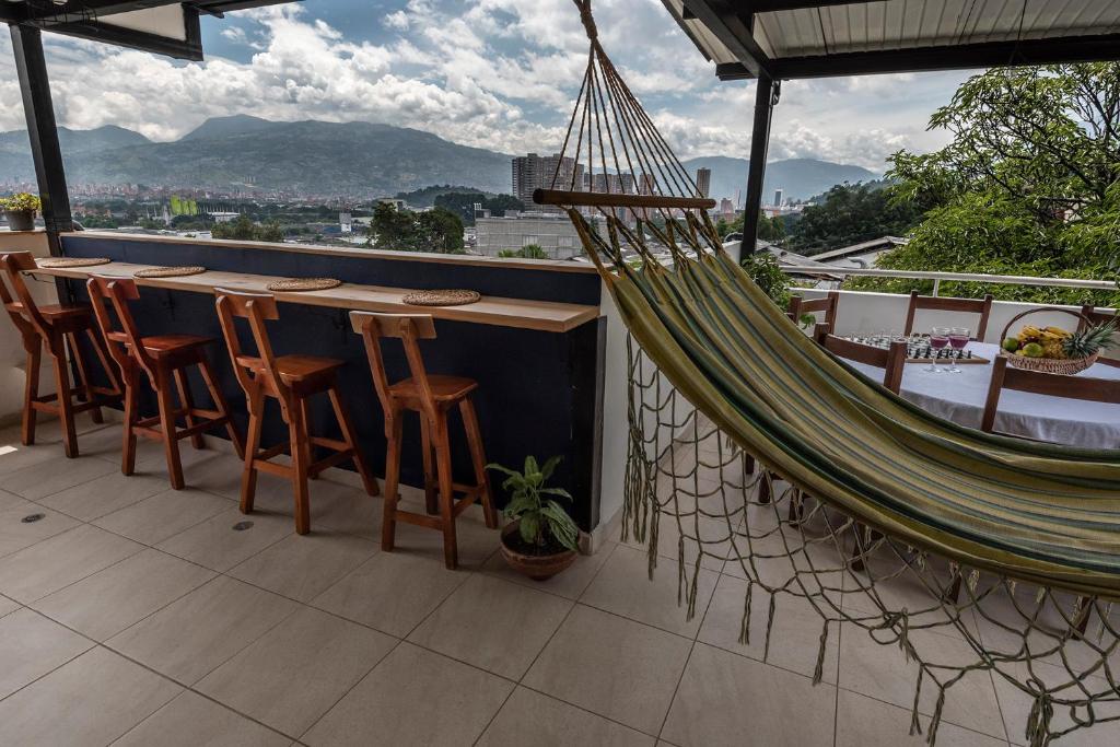 a hammock on a balcony with a table and chairs at Poblado Guest House in Medellín