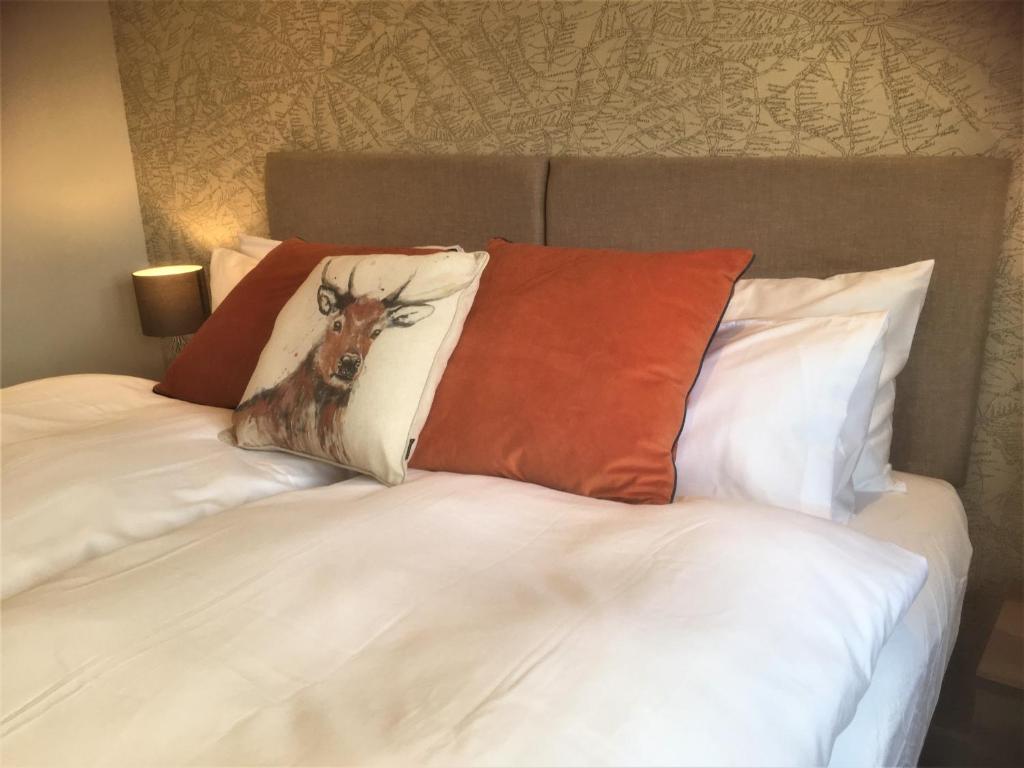 Una cama con una almohada con un ciervo. en The Grange Silverstone, en Towcester