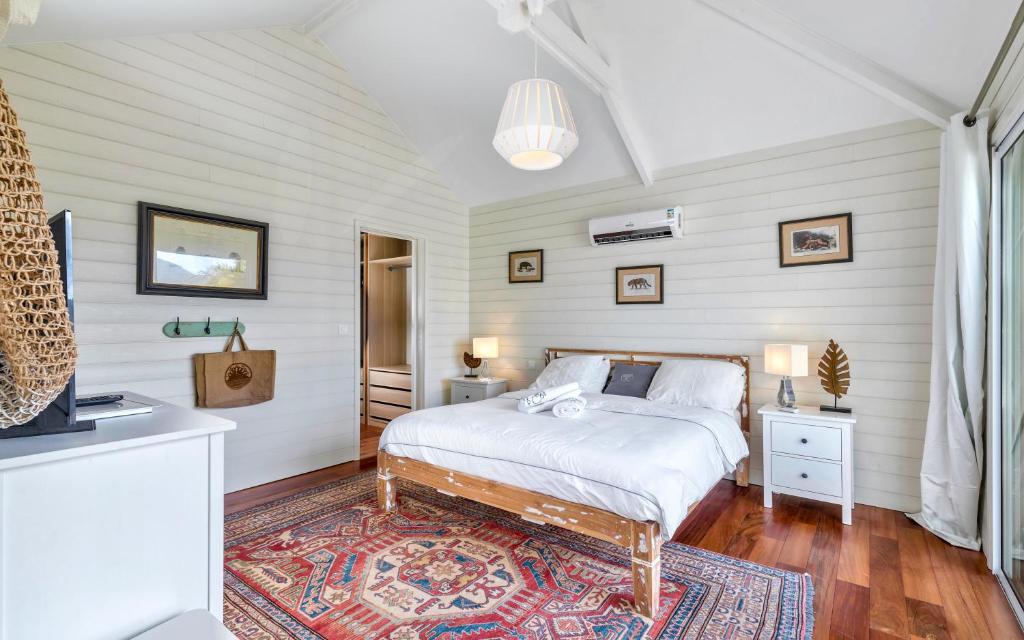 - une chambre avec un lit et un tapis dans l'établissement Villa La Voile Blanche, à La Baie-Orientale