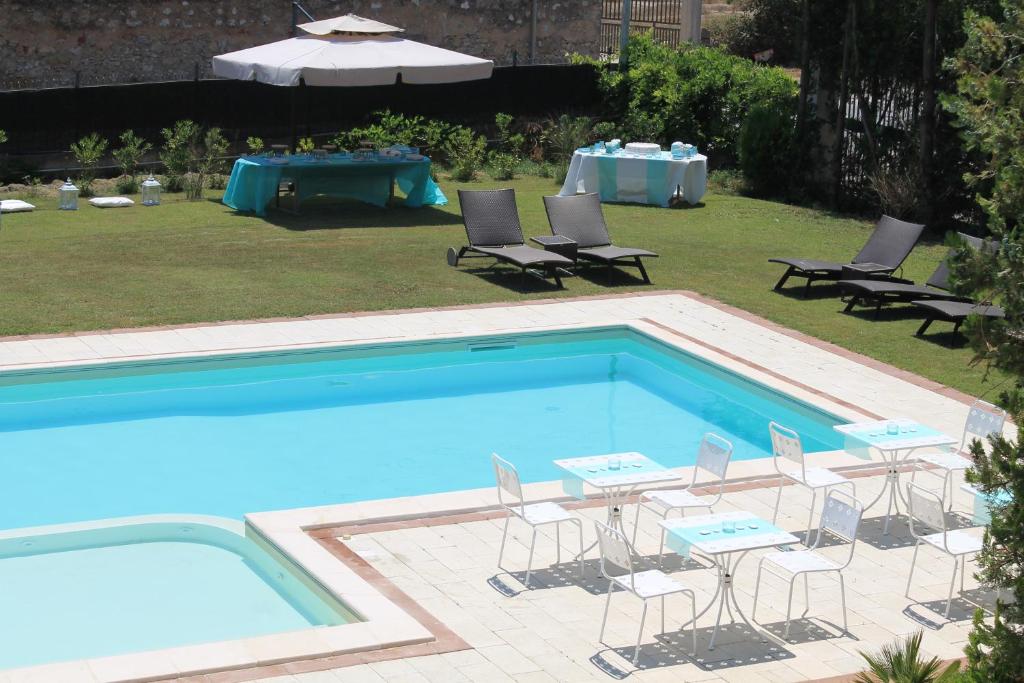 Il Gelso Nero في فيتوريا: حمام سباحة به كراسي وطاولة وطاولة وطاولة بجانب السرير