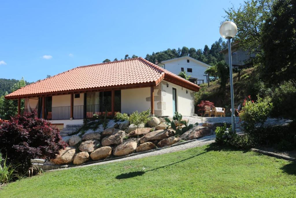 a house with a rock garden in front of it at Quinta da Vinha do Souto in Arouca
