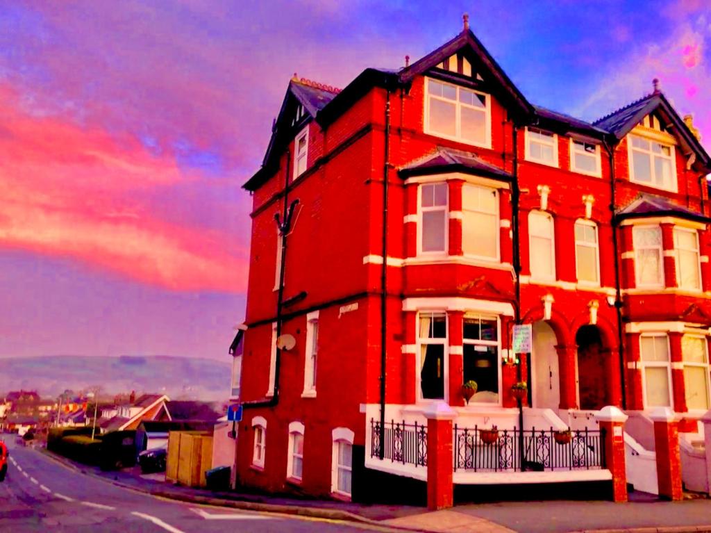 um edifício vermelho numa rua com um céu vermelho em Greylands Guest House em Llandrindod Wells