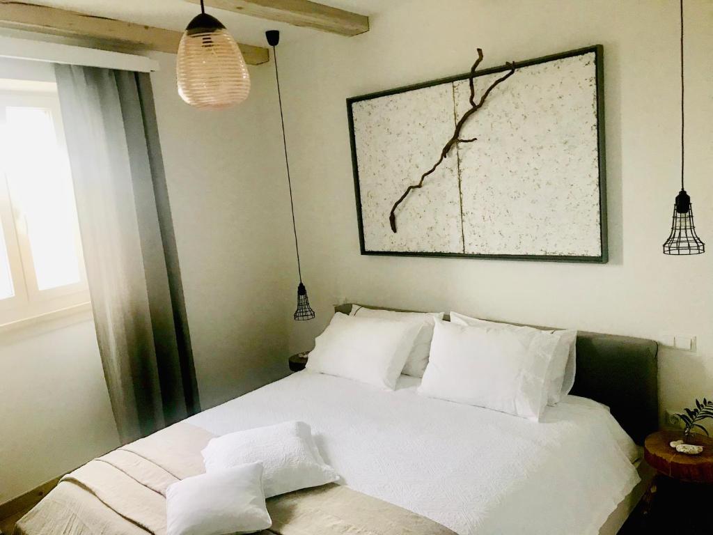een slaapkamer met een bed met witte lakens en kussens bij Familia in Selca