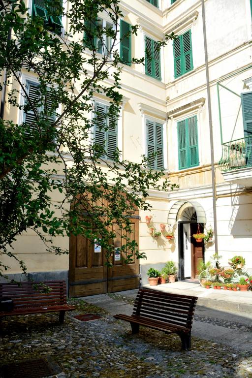 a building with two benches in front of it at Ciassa Noeva in Pieve di Teco