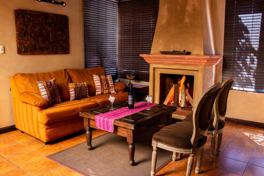 a living room with a couch and a table and a fireplace at All Suite El Marques de Antigua in Antigua Guatemala