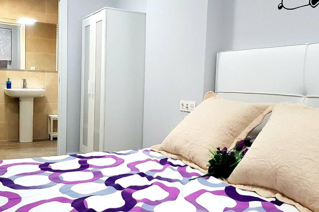 1 dormitorio con 1 cama con alfombra morada y blanca en LAIA HOME GARAJE Y WIFI en Barakaldo