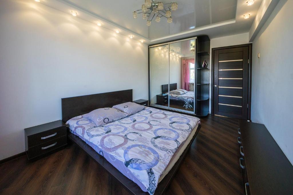 a bedroom with a bed and a large mirror at Flat on Dneprovsky boulevard in Mogilev