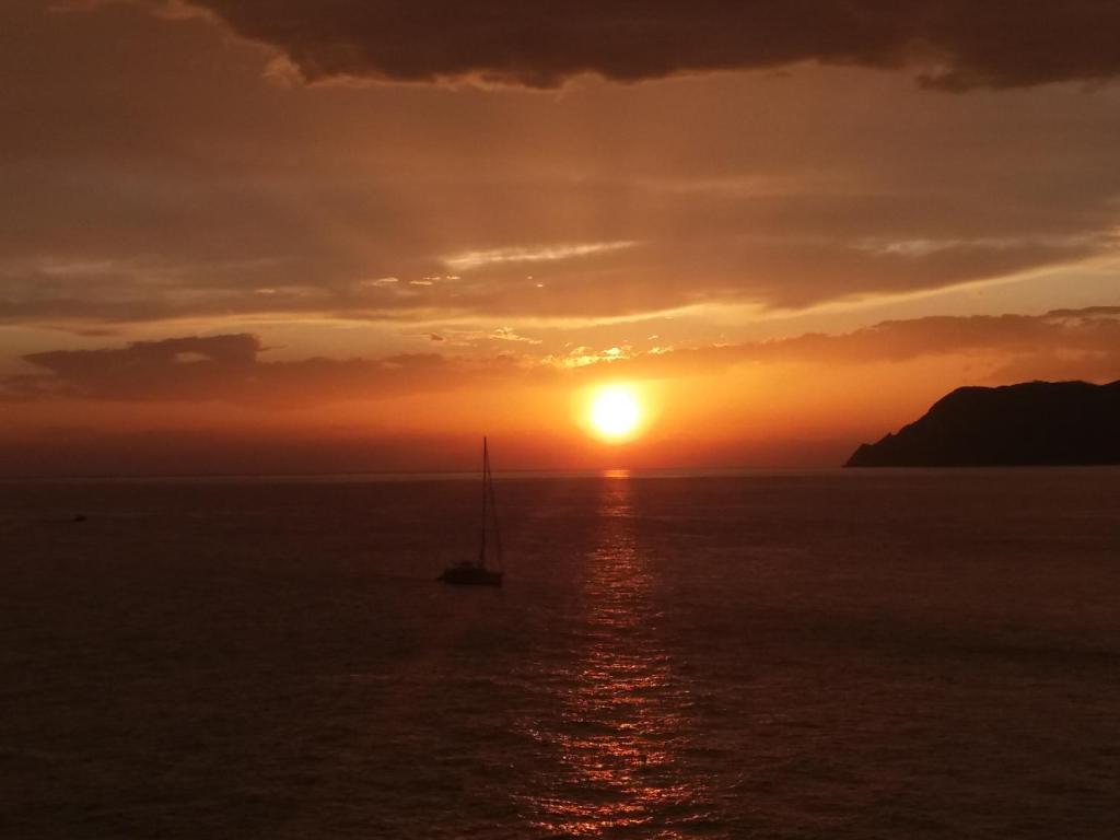 ein Segelboot im Ozean bei Sonnenuntergang in der Unterkunft Ca'la Luna - in centro con terrazza in Riomaggiore