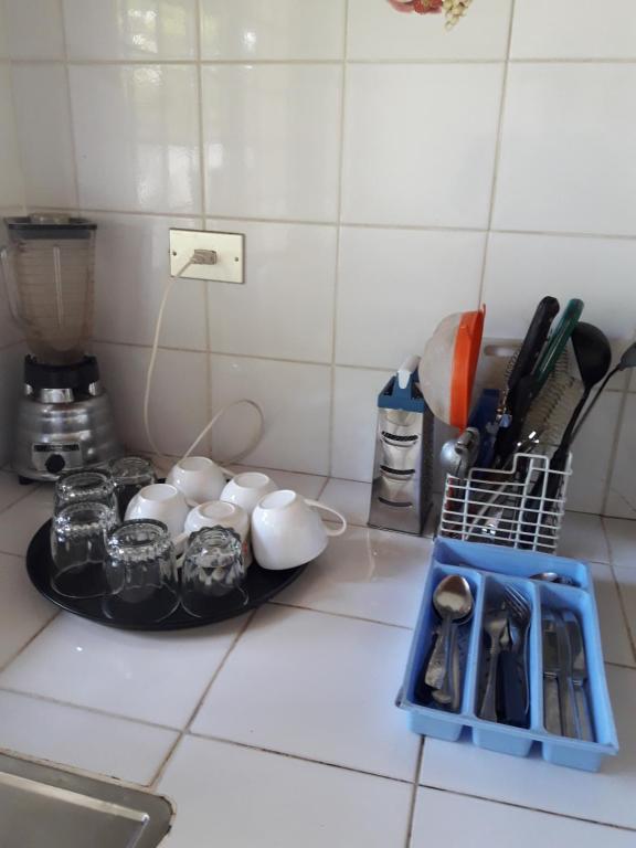 a kitchen counter with a plate with cups and utensils at Casas Vacacionales La Cima in Mérida