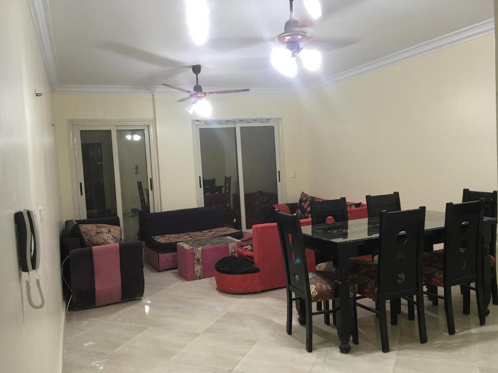 ein Wohnzimmer mit einem Tisch, Stühlen und einem Sofa in der Unterkunft Qronful in Kairo