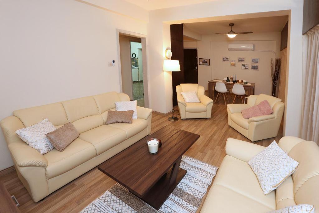 sala de estar con sofá, sillas y mesa en The Bridge-House Apartment, en Nicosia
