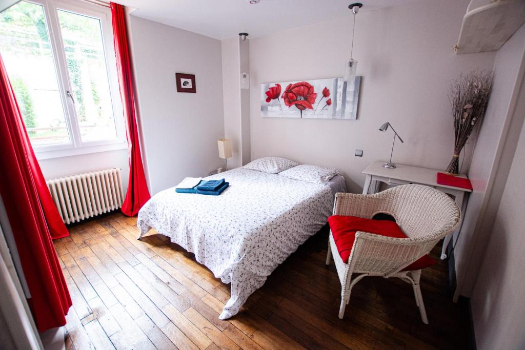 una camera con un letto e una sedia e una finestra di Les Trois Fontaines a Poitiers