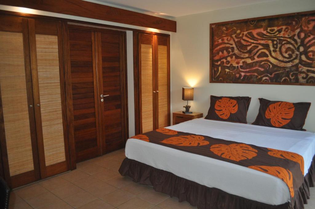 a bedroom with a large bed with a large painting on the wall at ROYAL BORA BORA in Bora Bora