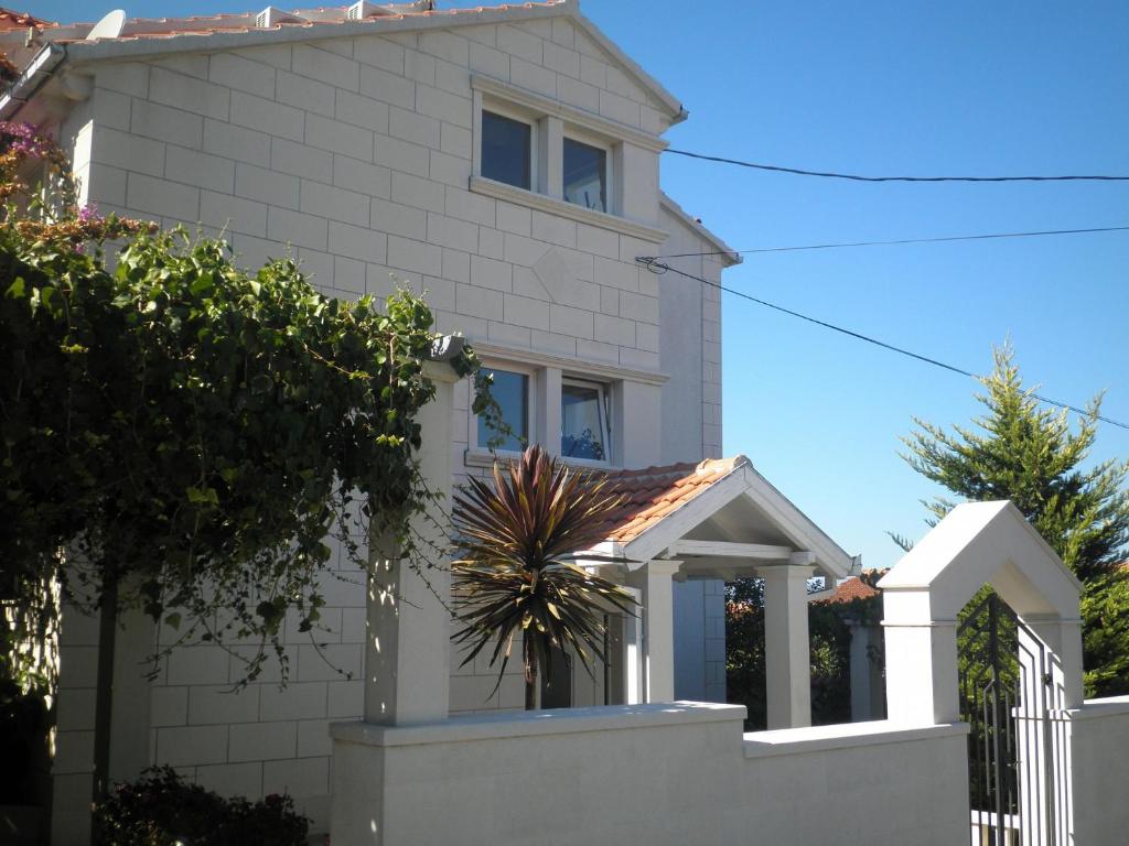 a white house with a gate and a fence at Apartments Aldica - 300 m from sea in Supetar