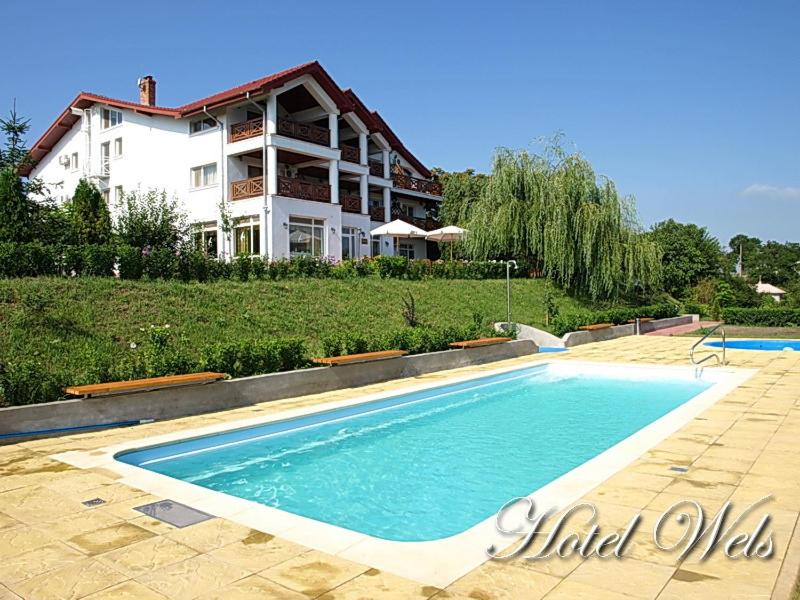 uma piscina em frente a uma casa em Hotel Wels em Băltenii de Sus