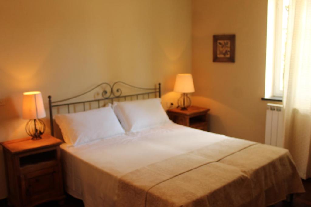 una camera con un letto bianco e 2 lampade di Locanda del Sale a Genova