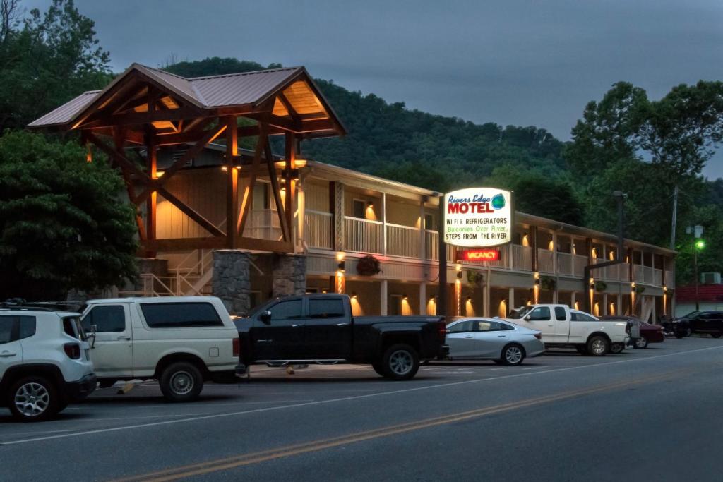 ein LKW, der vor einem Hotel geparkt ist, mit einem Schild in der Unterkunft Rivers Edge Motel in Cherokee