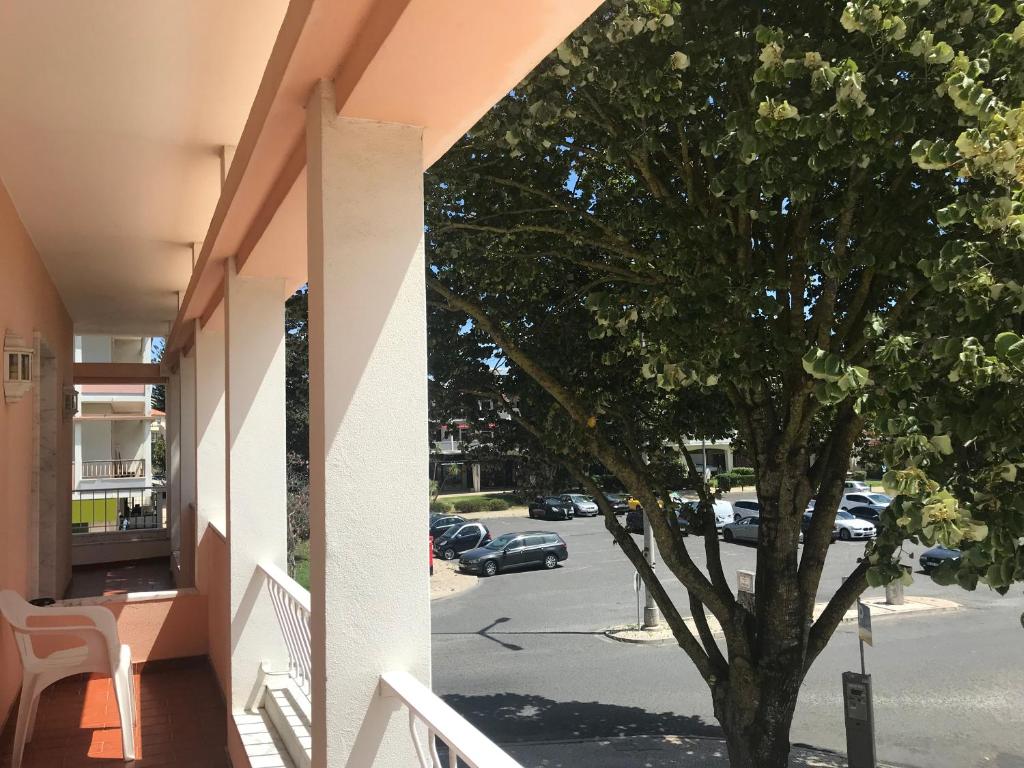 a tree on the side of a building next to a street at Atlantic Waves Accommodation in Carcavelos