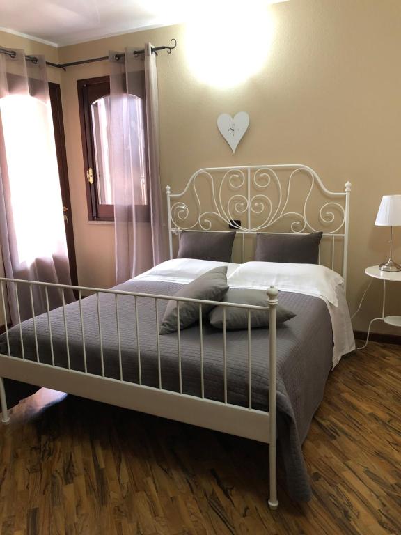 um quarto com uma cama branca com um coração na parede em B&B Martina em Assemini