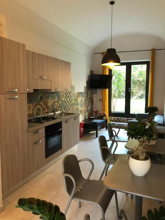 a kitchen and living room with a table and chairs at Vesuvius Gardens - Fagianeria Borbonica Relais in Ercolano
