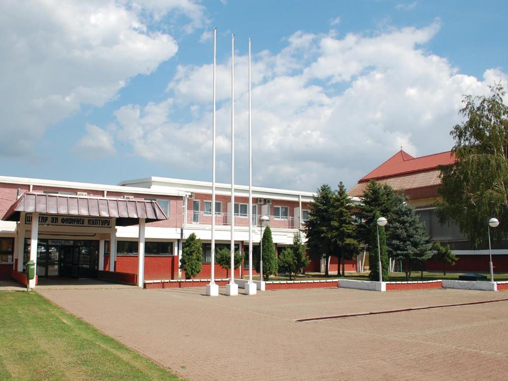 a large building with white poles in front of it at Holiday Park CFK in Vrbas