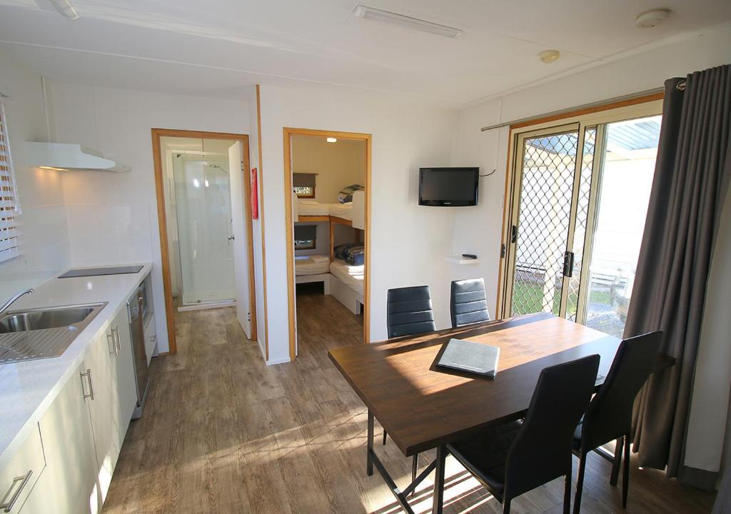a kitchen and dining room with a table and chairs at Beauty Point Tourist Park in Beauty Point