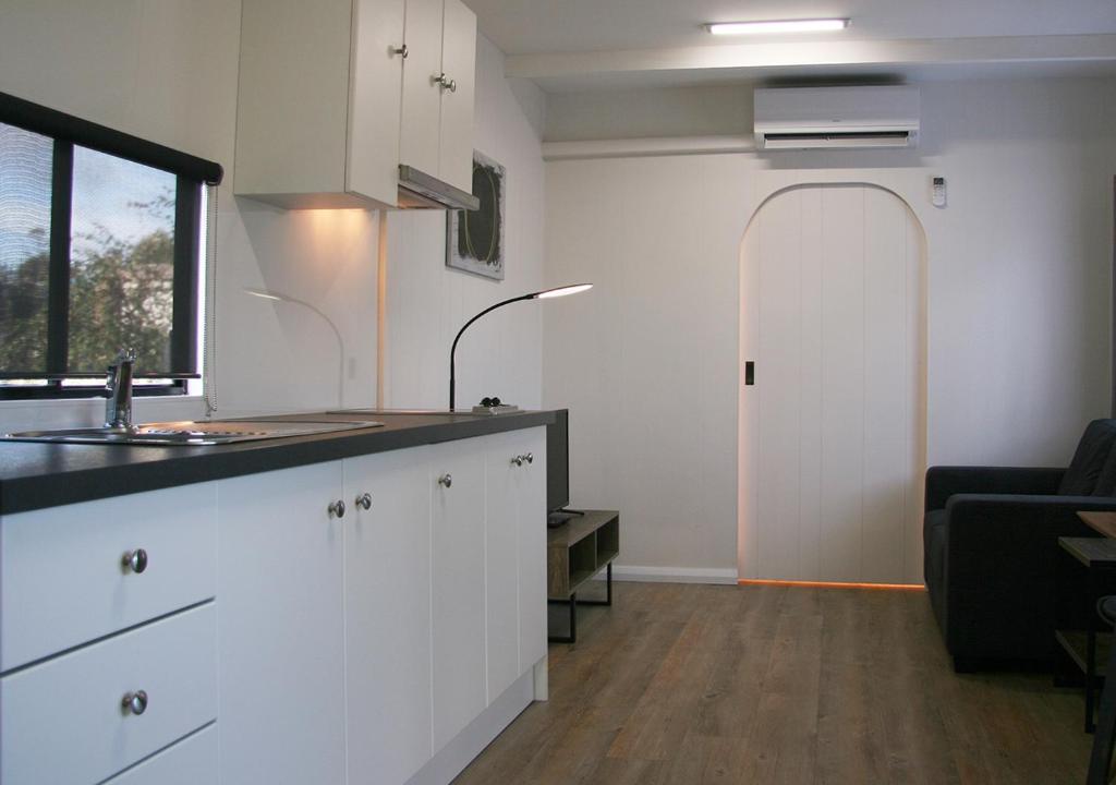 a kitchen with white cabinets and a sink and a window at Beauty Point Tourist Park in Beauty Point