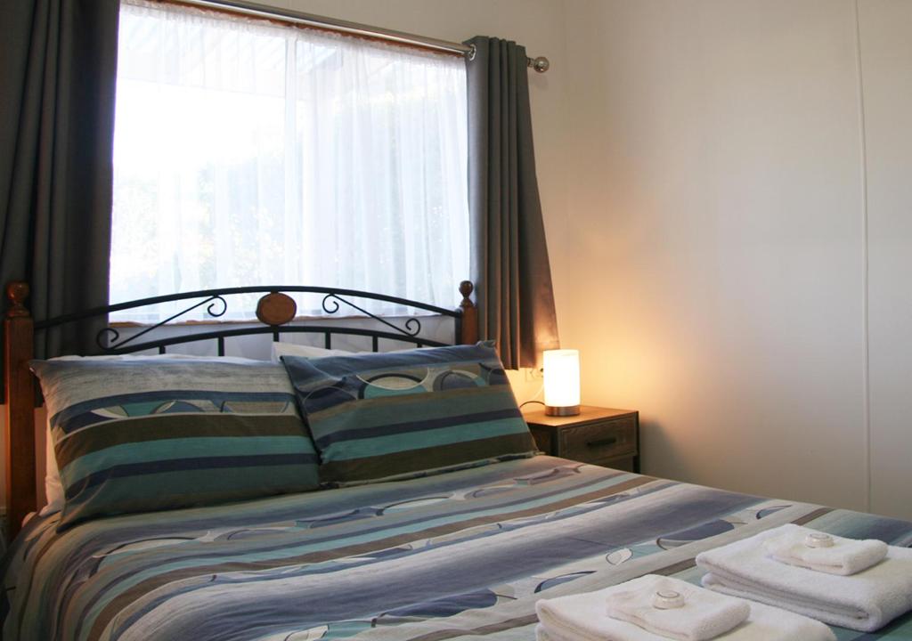 a bedroom with a bed with towels on it at Beauty Point Tourist Park in Beauty Point