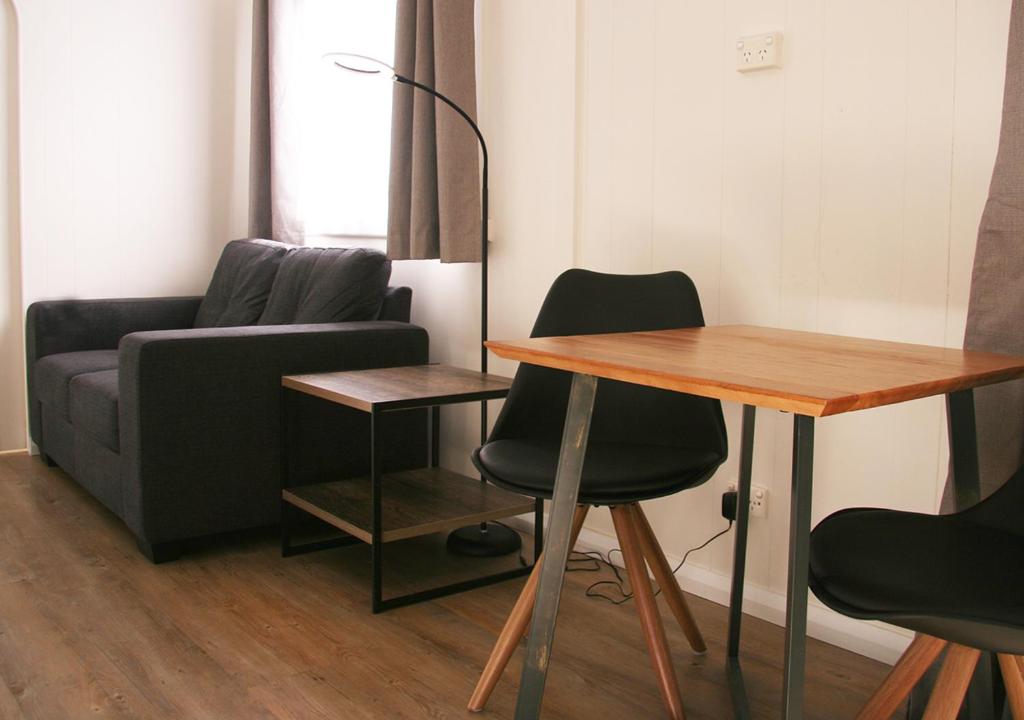 a living room with a couch and a table and chairs at Beauty Point Tourist Park in Beauty Point