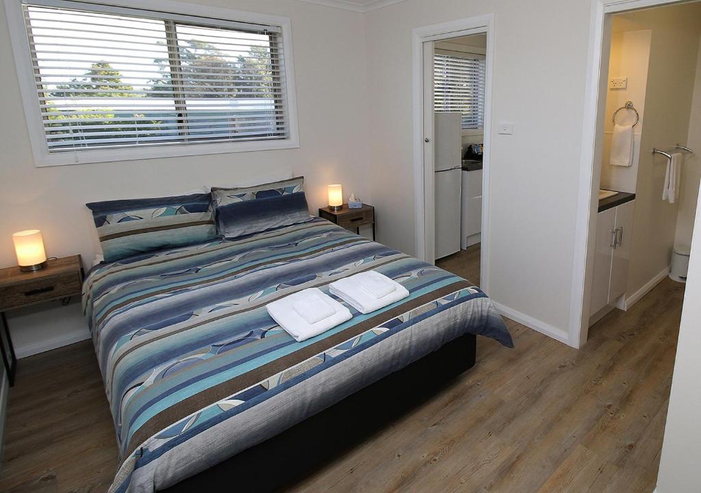 a bedroom with a large bed with two towels on it at Beauty Point Tourist Park in Beauty Point