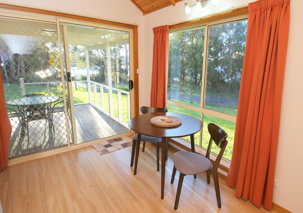 a room with a table and chairs and a large window at Beauty Point Tourist Park in Beauty Point