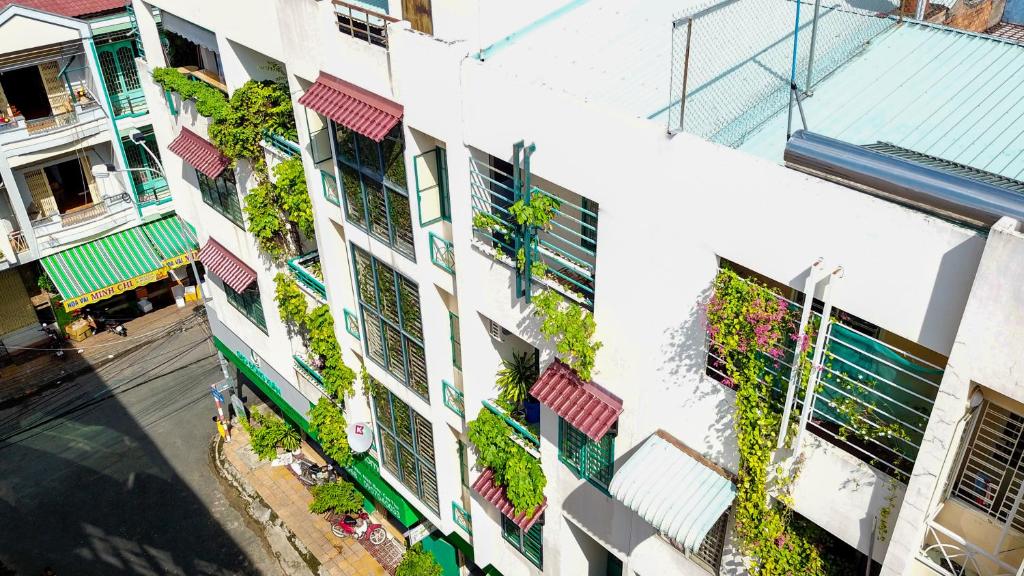 um edifício de apartamentos com plantas nas suas janelas em Winter Spring Homestay em Can Tho
