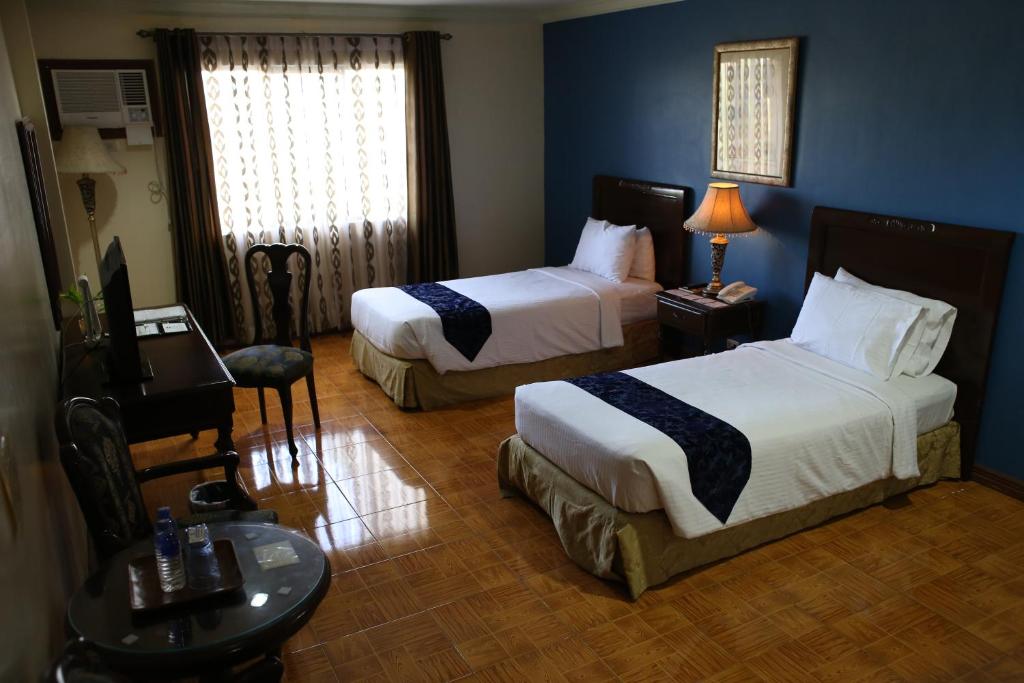 Postel nebo postele na pokoji v ubytování Crown Royale Hotel