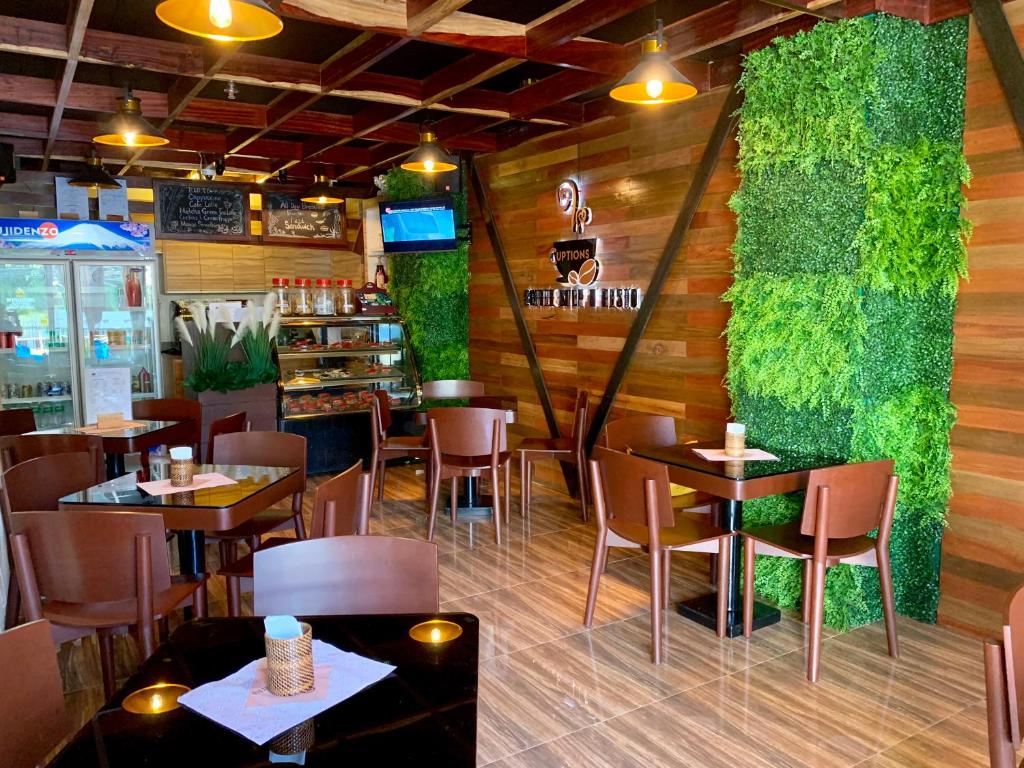 a restaurant with tables and chairs and a green wall at Davao Persimmon Suites in Davao City