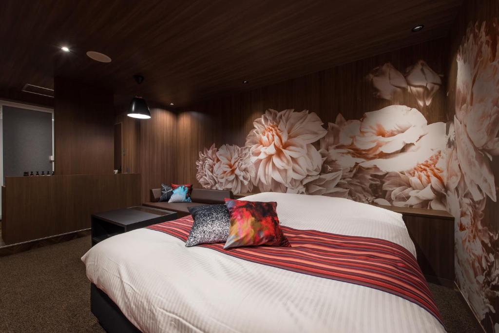 um quarto com uma cama grande e um mural de flores em HOTEL FARINA DOLCE (Adult Only) em Kanuma