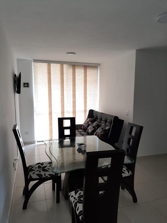 a living room with a glass table and chairs at APARTAMENTO AVENIDA CONDINA Primer Piso in Pereira