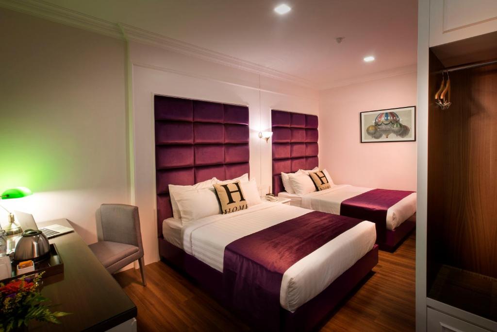 Habitación de hotel con 2 camas y escritorio en H Boutique Hotel Sri Petaling, en Kuala Lumpur