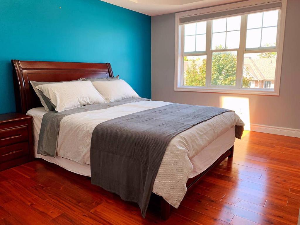 a bedroom with a large bed with a blue wall at Nice rooms with private bath in Mid Town Toronto in Toronto